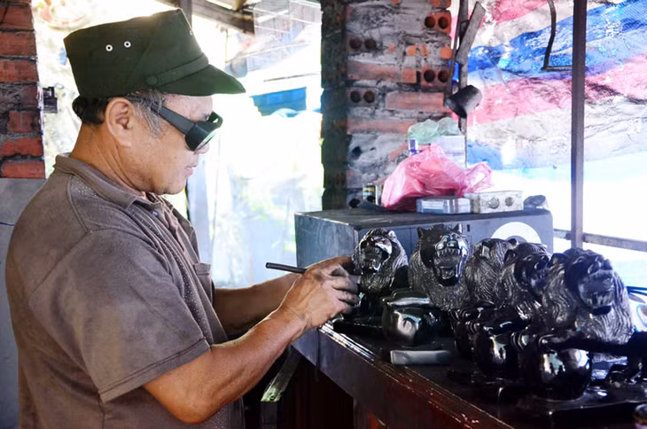 Ông Nguyễn Tiến Chín tỉ mỉ chạm khắc từng chi tiết cho tác phẩm sư tử bằng than đá...