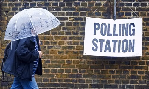 Một người đàn ông che ô đi bỏ phiếu trưng cầu dân ý ở London, Anh, ngày 23/6. Ảnh: AFP.
