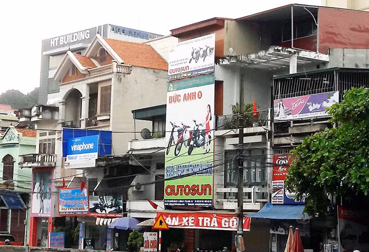 Việc lắp đặt các biển quảng cáo không đúng quy cách làm cho bộ mặt phố, phường thiếu mỹ quan. (Ảnh chụp ngày 22-6-2016 trên tuyến QL18, phường Hồng Hà, TP Hạ Long).