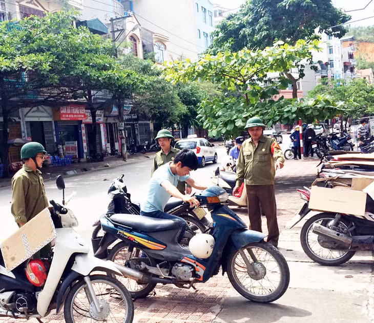 CCB phường Bãi Cháy nhắc nhở, hướng dẫn người dân đỗ xe đúng phần đường quy định.