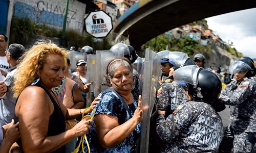 Người biểu tình đụng độ với cảnh sát ở Caracas. Ảnh: AFP.