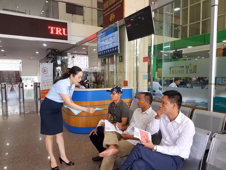 Cán bộ Bộ phận Kiểm tra - Giám sát Trung tâm HCC tỉnh phát phiếu đánh giá cho công dân đến Trung tâm giao dịch. Ảnh: Nguyễn Huế