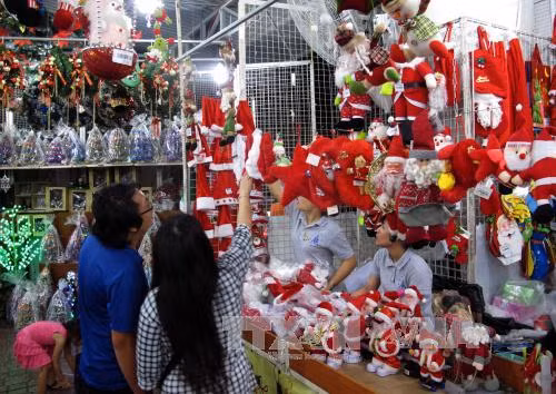 Khách chọn mua đồ trang trí Noel tại một cửa hàng Quận 3. Ảnh: Phương Vy/TTXVN