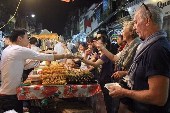 Chợ đêm phố cổ Hà Nội. Chợ đêm phố cổ mở vào 3 ngày cuối tuần, từ 18h đến 23h, là điểm đến quen thuộc với nhiều du khách đến Hà Nội. Các mặt hàng ở chợ đa dạng, đẹp mắt. Đầu phố Hàng Đào là một dãy hàng ăn vặt với các loại hoa quả như dứa, mận, xoài, cóc... dầm chua ngọt, màu sắc hấp dẫn. Đi sâu vào trong phố Hàng Đào, Hàng Ngang đến Hàng Giấy là các gian bán sản phẩm lưu niệm, quần áo, giầy dép với đủ kích cỡ, màu sắc. Trong đó, các quầy đồ thủ công mỹ nghệ luôn nhận được sự quan tâm của du khách nước ngoài. Thời điểm đông vui nhất vào khoảng 20h-22h. Điều thuận tiện cho du khách là phiên chợ chỉ dành cho người đi bộ, không có các phương tiện như ô tô, xe máy cản trở. Ảnh: Võ Tuyết.