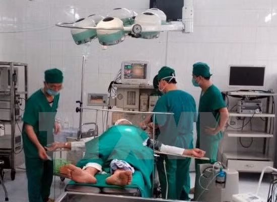 Các bác sỹ tiến hành phẫu thuật cho ông Ma Văn Nhật. (Ảnh: TTXVN)