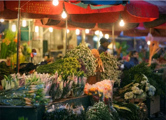 Chợ hoa đêm Quảng Bá. Chợ hoa đêm lớn nhất Hà Nội thông thường họp vào khoảng nửa đêm đến 3h - 4h sáng, những ngày cận Tết sẽ họp từ sáng đến tối. Do đó, du khách có thể ghé qua bất cứ lúc nào. Những xe hoa lớn nhỏ đủ loại, màu sắc tấp nập đổ về chợ. Những ngày cuối năm hoa đào, cúc, ly được bày bán nhiều hơn. Đi chợ hoa nhiều khi trở thành thú vui của nhiều du khách. Có người thức trắng đêm để lang thang trong chợ không hẳn để mua hoa mà đơn giản chỉ là cảm nhận một phần trong cuộc sống Hà Nội về đêm. Ảnh: Nguyễn Hòa Khánh.