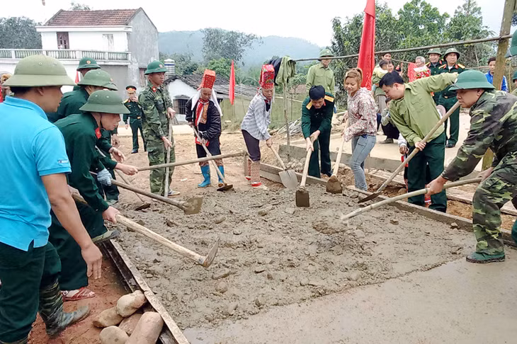 Cán bộ, chiến sĩ Lâm trường 103 giúp nhân dân làm đường giao thông.