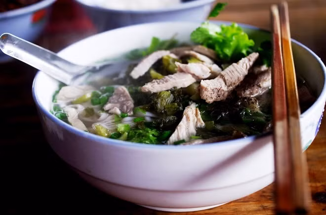 Ăn sáng bằng phở chua Một món ngon dân dã khác của người dân Bắc Hà là phở chua. Khu ăn uống của chợ phiên này cũng có rất nhiều hàng quán bán phở chua cho khách chọn. Bát phở chua đầy đặn từ thịt, dưa chua, bánh phở tới rau thơm, ớt, muối ăn kèm. Một bát phở có giá 20.000 đồng.