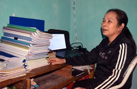 Cô giáo Lưu Thị Hồng, một giáo viên già nhất trường, bên chồng giáo án 12 quyển.