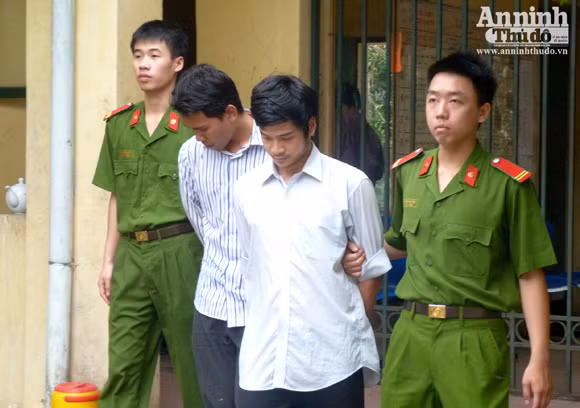 Lực lượng cảnh sát dẫn giải Bình và Hương về nhà tạm giữ