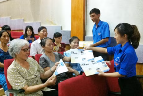 Các đoàn viên thanh niên phát tờ rơi tuyên truyền Luật ATGT đường thủy cho người dân 