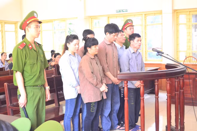 Ông trùm ma túy Lê Quang Đông (đứng hàng đầu, mặc quần bò, áo màu nâu) cùng các bị cáo trong phiên xét xử.