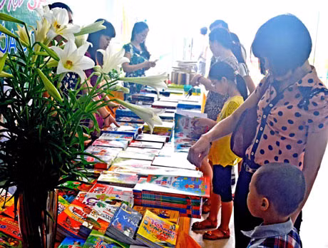 Một số phụ huynh chọn mua sách thiếu nhi tại gian bày bán trong Ngày hội văn hoá đọc 2014 ở Thư viện tỉnh.