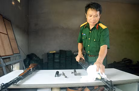 Đại uý Đới Văn Bính bảo dưỡng vũ khí để chuẩn bị cho buổi huấn luyện bắn đạn thật của đơn vị.