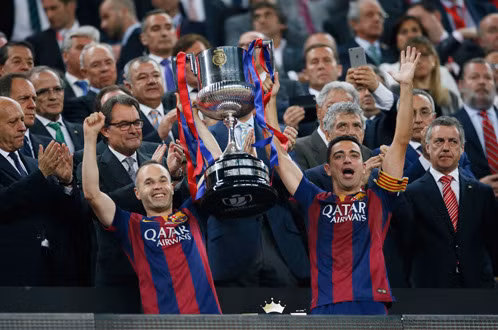 Xavi và Iniesta giơ cao chiếc Cúp nhà vua TBN 2014-2015 - Ảnh: Reuters