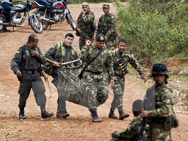 Binh sỹ Colombia chuyển tư trang và vũ khí của một đồng đội thiệt mạng sau vụ tấn công ở Cauca. (Nguồn: AFP/TTXVN)