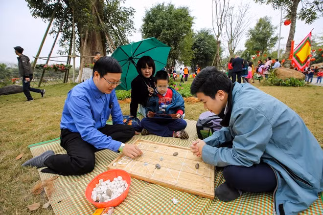 Cả gia đình cùng nhau thử sức ở các trò chơi dân gian. (Ảnh: Minh Sơn/Vietnam+)