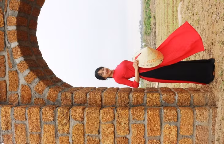 Hoàng Thị Kiều Hiên (24 tuổi) trong trang phục áo dài truyền thống cùng bạn du xuân, tạo dáng, ghi lại những hình ảnh của tuổi đôi mươi trong tiết trời mùa xuân se lạnh, lất phất mưa bay.