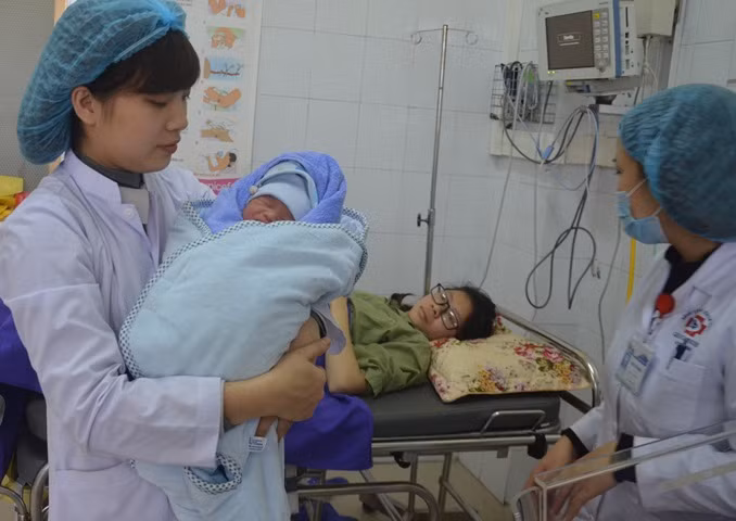 Nữ hộ sinh Phạm Thị Hải Yến ẵm bé Ngô Nhật Minh, nhà ở Cẩm Phả chào đời vào dịp Tết Mậu Tuất để đưa vào lồng ấp.