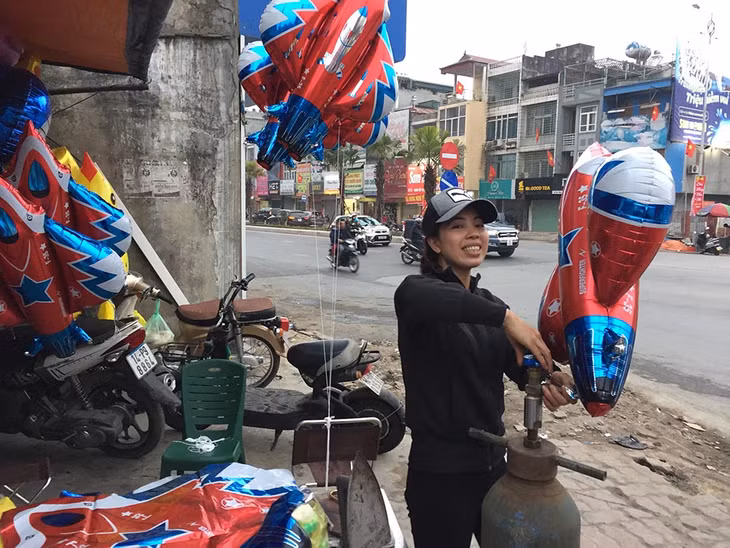 Chị Phạm Thị Thu, 34 tuổi, bán bóng bay ở khu vực ngã ba cứu hỏa, TP Hạ Long bán bóng bay để kiếm thêm thu nhập ngày Tết