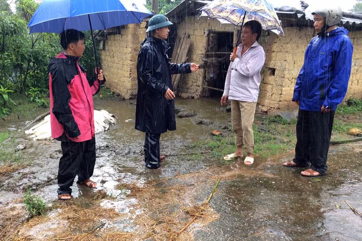 Tổ công tác của xã Đồng Tâm đội mưa đi vận động người dân trên địa bàn thực hiện Đề án 3 trong 1 (Ảnh do cơ sở cung cấp)