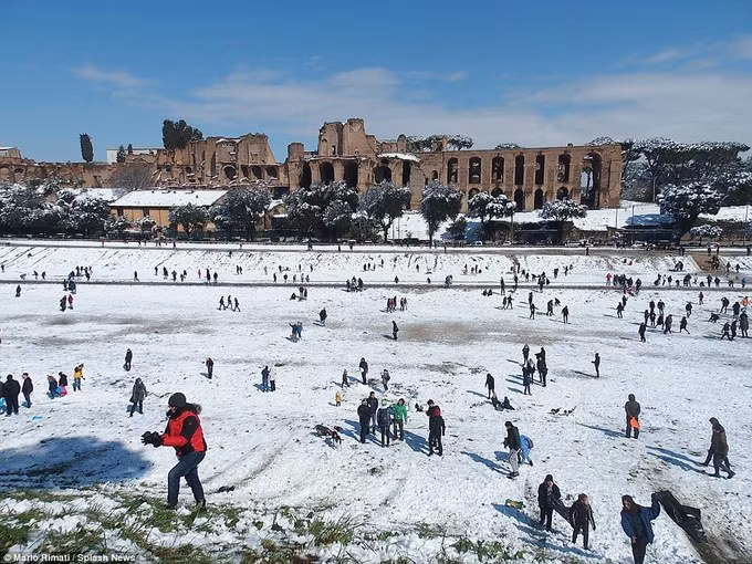 Người dân và du khách tập trung tại trường đua La Mã cổ đại Circo Massimo để chơi ném bóng tuyết và trượt dốc tuyết. Ảnh: Splash News.