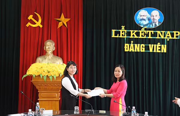 Đồng chí Phạm Thanh Huyền (Bí thư Chi bộ khoa Công nghệ thông tin, Trường Đại học Hạ Long, bên trái) trao Quyết định kết nạp đảng cho đảng viên mới. Ảnh: Trường Đại học Hạ Long