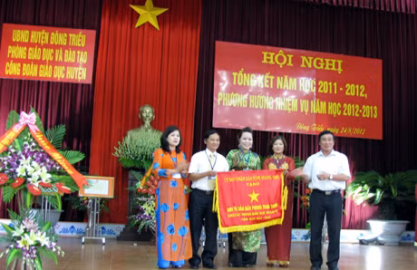 Nhà giáo ưu tú Đỗ Văn Thuấn, Giám đốc Sở GD-ĐT trao cờ cho tập thể lãnh đạo Phòng GD-ĐT huyện Đông Triều