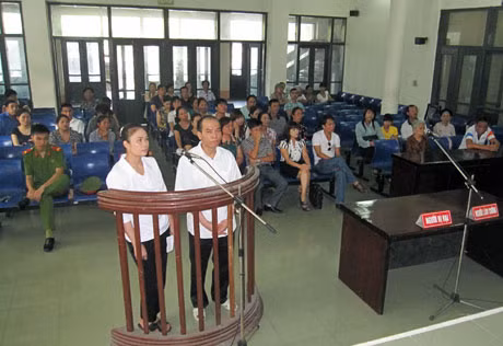 Cặp vợ chồng lừa đảo đứng trước vành móng ngựa tại phiên toà xét xử sơ thẩm.