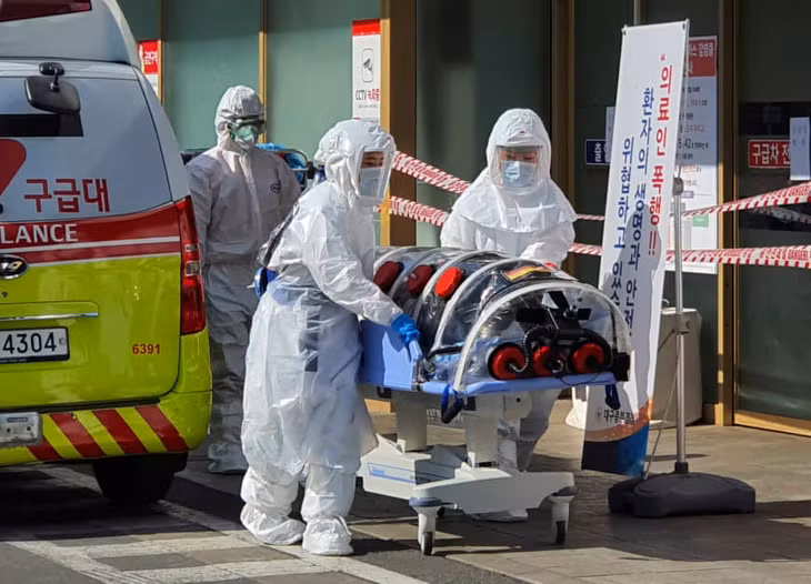 Nhân viên y tế đưa bệnh nhân nghi nhiễm virus Corona chủng mới vào Bệnh viện trường Đại học Quốc gia Kyungpook ở Daegu, Hàn Quốc ngày 19/2. Ảnh: Yonhap 