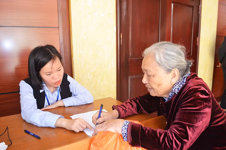 Cán bộ Trung tâm Phát triển quỹ đất TP Hạ Long hướng dẫn người dân viết đơn kiến nghị.