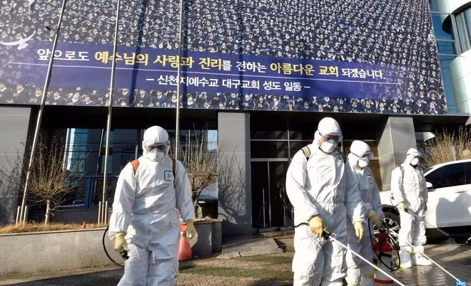 Nhân viên y tế Daegu phun thuốc khử trùng bên ngoài nhà thờ của giáo phái Tân Thiên Địa, nơi có liên hệ với hàng trăm ca nhiễm Covid-19 ở thành phố. (Ảnh: Reuters)
