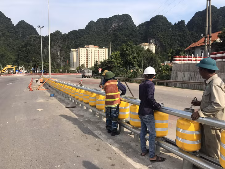 Công nhân đang tiến hành lắp con trượt trên hệ thống giải phân cách đoạn xuống dốc của ngã 3 Quang Hanh (Cẩm Phả)