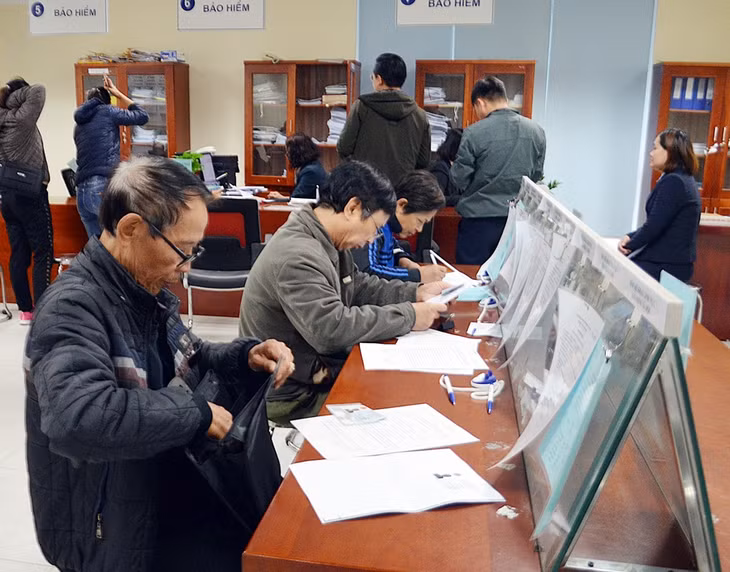 Người dân ghi thông tin cá nhân về giải quyết thủ tục liên quan chính sách BHXH, BHYT tại Trung tâm Phục vụ hành chính công TP Hạ Long.