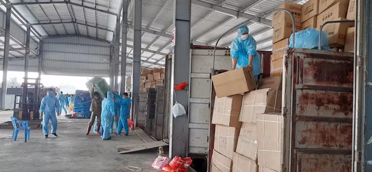 Các lực lượng chức năng và công nhân bốc xếp hàng hóa tại khu vực kiểm hóa cầu Bắc Luân 2 thực hiện nghiêm ngặt các quy trình phòng, chống dịch.