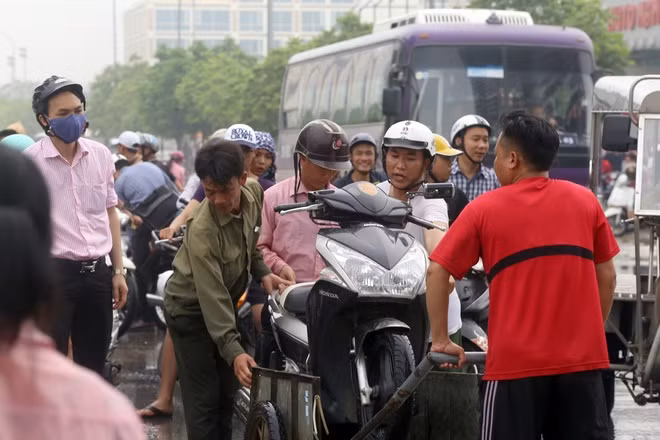  Khu vực này có khoảng 5-6 nhóm, mỗi nhóm 3-4 người vừa kéo vừa giữ cho phương tiện khỏi rơi xuống đường. "Thấy nhiều người dân đứng chôn chân cả tiếng không qua được, thậm chí xe chết máy nên chúng tôi đã nghĩ ra cách này để kiếm thêm, cũng là để giúp họ vượt qua đoạn đường ngập", ông Nguyễn Văn Quang ở Mễ Trì, cho hay.