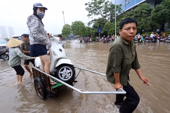  Nhóm người ở làng Mễ Trì từ 6h30 sáng đã nghĩ cách mang xe cải tiến ra chở xe máy với giá 50 nghìn đồng cả người lẫn xe qua đoạn đường 100 m từ sau toà Keangnam tới đường Mễ Trì.