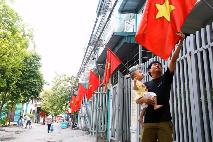 Người dân náo nức treo cờ tổ quốc chào đón ngày hội lớn.