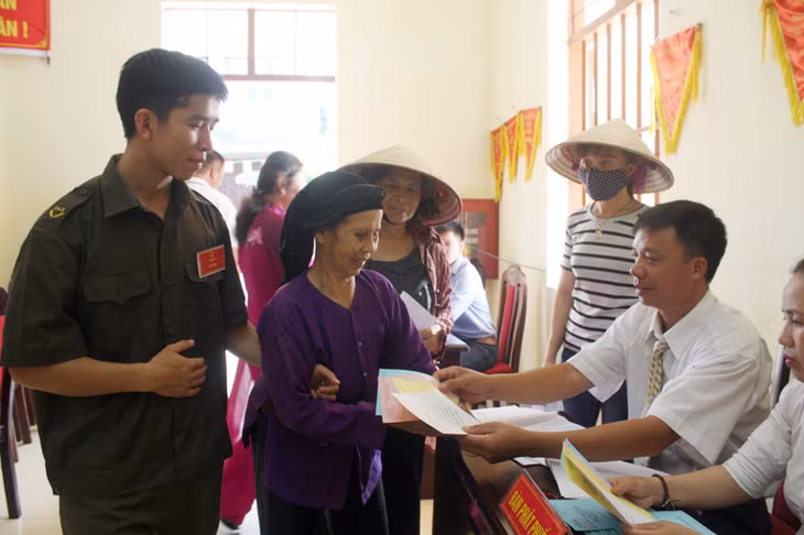 Cử tri tại khu vực bỏ phiếu số 2, xã Hoàng Tân, TX Quảng Yên nhận phiếu bầu cử.