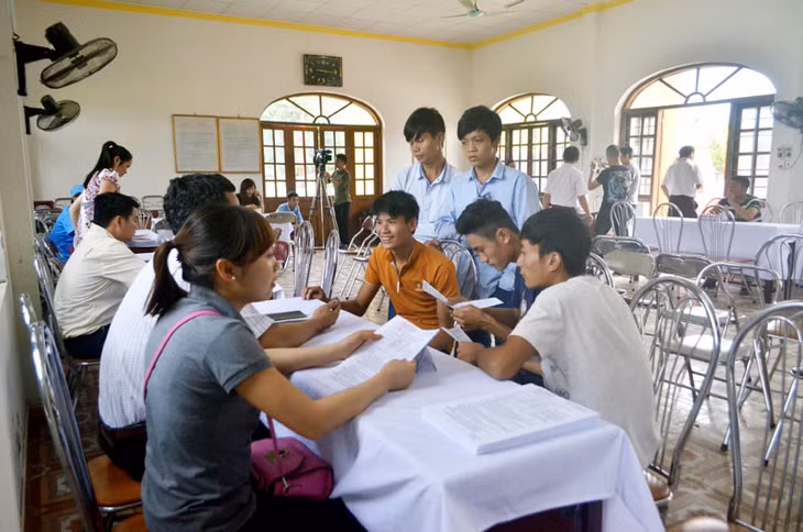 Một nhóm lao động trẻ nghe tư vấn tuyển sinh tại bàn tư vấn của Trường cao đẳng nghề Việt - Hàn.
