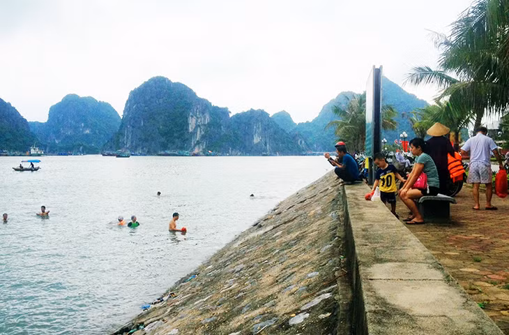 Người dân tắm biển tại bãi tắm tự phát khu vực hòn Cặp Bè, phường Bạch Đằng.