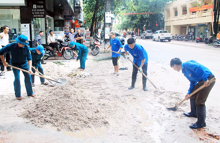 ĐVTN huyện Hoành Bồ phối hợp với lực lượng dân quân tự vệ, dọn dẹp vệ sinh tại khu vực thị trấn Trới do ảnh hưởng của đợt mưa lụt cuối tháng 7-2015.