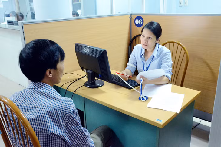Cán bộ Trung tâm Giới thiệu việc làm tỉnh tư vấn cho người lao động nộp hồ sơ đăng ký bảo hiểm thất nghiệp. Ảnh: Thanh Tùng