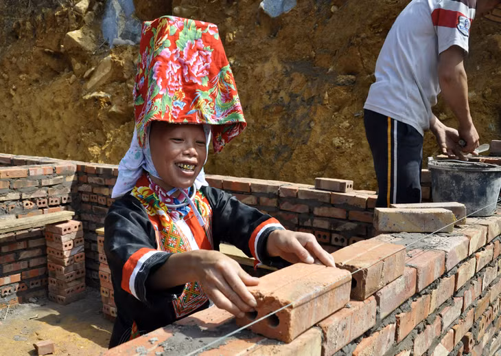 Chị Chìu Nhì Múi phấn khởi tự tay tham gia xây dựng ngôi nhà mới của gia đình (Ảnh chụp tại thôn Sông Móoc B, xã Đồng Văn huyện Bình Liêu, ngày 16/10/2015)