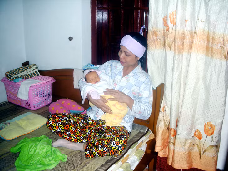 Chị Thanh đang bế cô con gái nhỏ mới sinh.