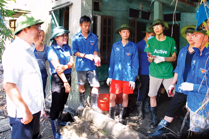 Đồng chí Nguyễn Quang Điệp thăm và động viên các đội thanh niên tình nguyện giúp dân khắc phục hậu quả đợt mưa lụt lịch sử cuối tháng 7-2015 tại thôn Khe Sím, xã Dương Huy, TP Cẩm Phả. Ảnh: PV