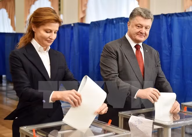 Tổng thống Ukraine Petro Poroshenko (phải) và phu nhân bỏ phiếu tại một địa điểm bầu cử ở Kiev. (Nguồn: AFP/TTXVN)