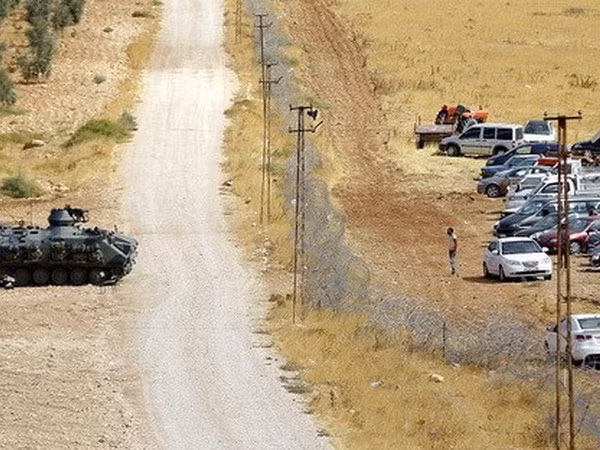 Một chiếc xe tăng Thổ Nhĩ Kỳ và hàng chục xe ôtô của dân Syria ở khu vực biên giới. (Nguồn: EPA)