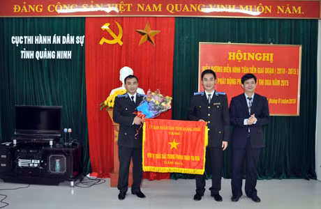 Đồng chí Lê Quang Tùng, Phó Chủ tịch UBND tỉnh trao cờ dẫn đầu phong trào thi đua công tác thi hành án năm 2014 của UBND tỉnh cho Cục Thi hành án dân sự TP Cẩm Phả
