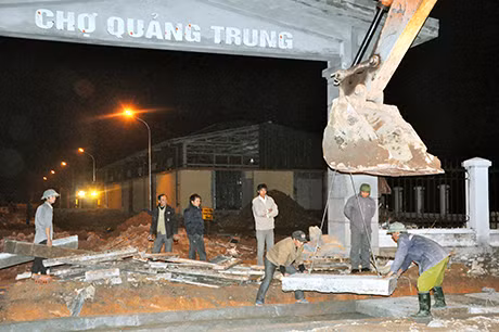 Lúc này trên công trường, các tổ công nhân đang miệt mài làm việc, ngay cổng vào là tốp thợ đang lắp đặt bê tông chịu lực để nắp cống thoát nước (ảnh 1). 